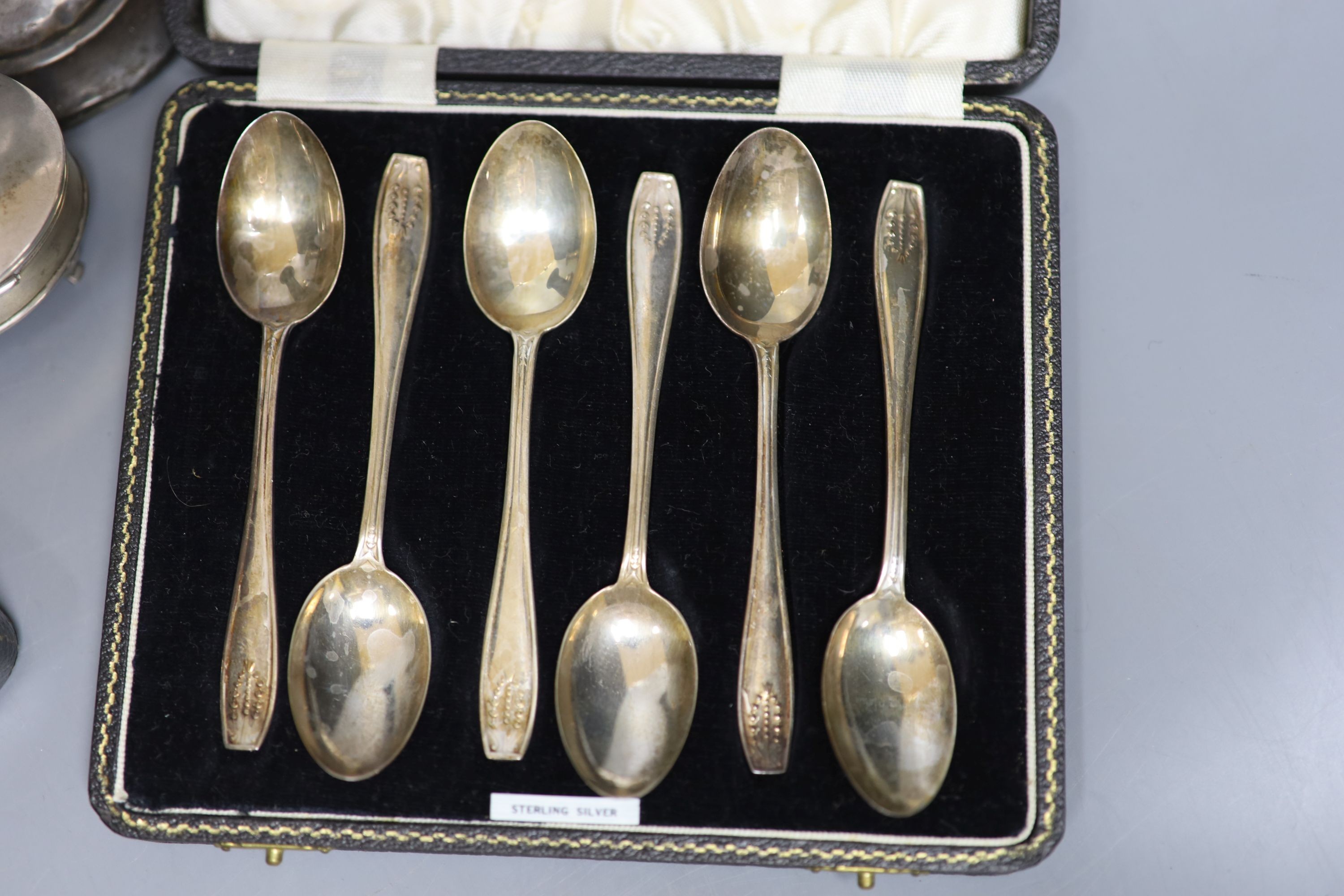 A pair of silver dwarf candlesticks(a,7.f.), 13cm, a small silver trinket box, a silver pepperette and two cased silver sets including a pair of salts and set of six teaspoons.